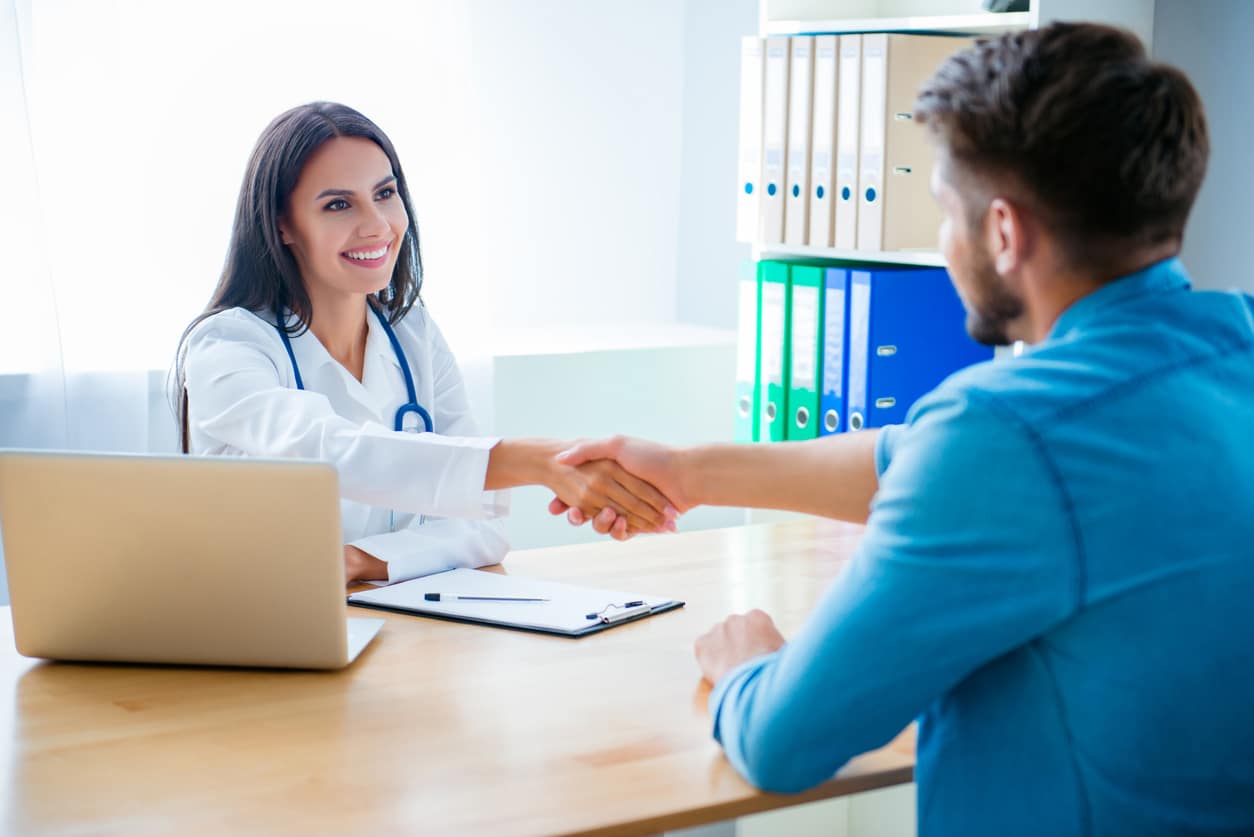 Happy doctor shaking hand of her healthy patient
